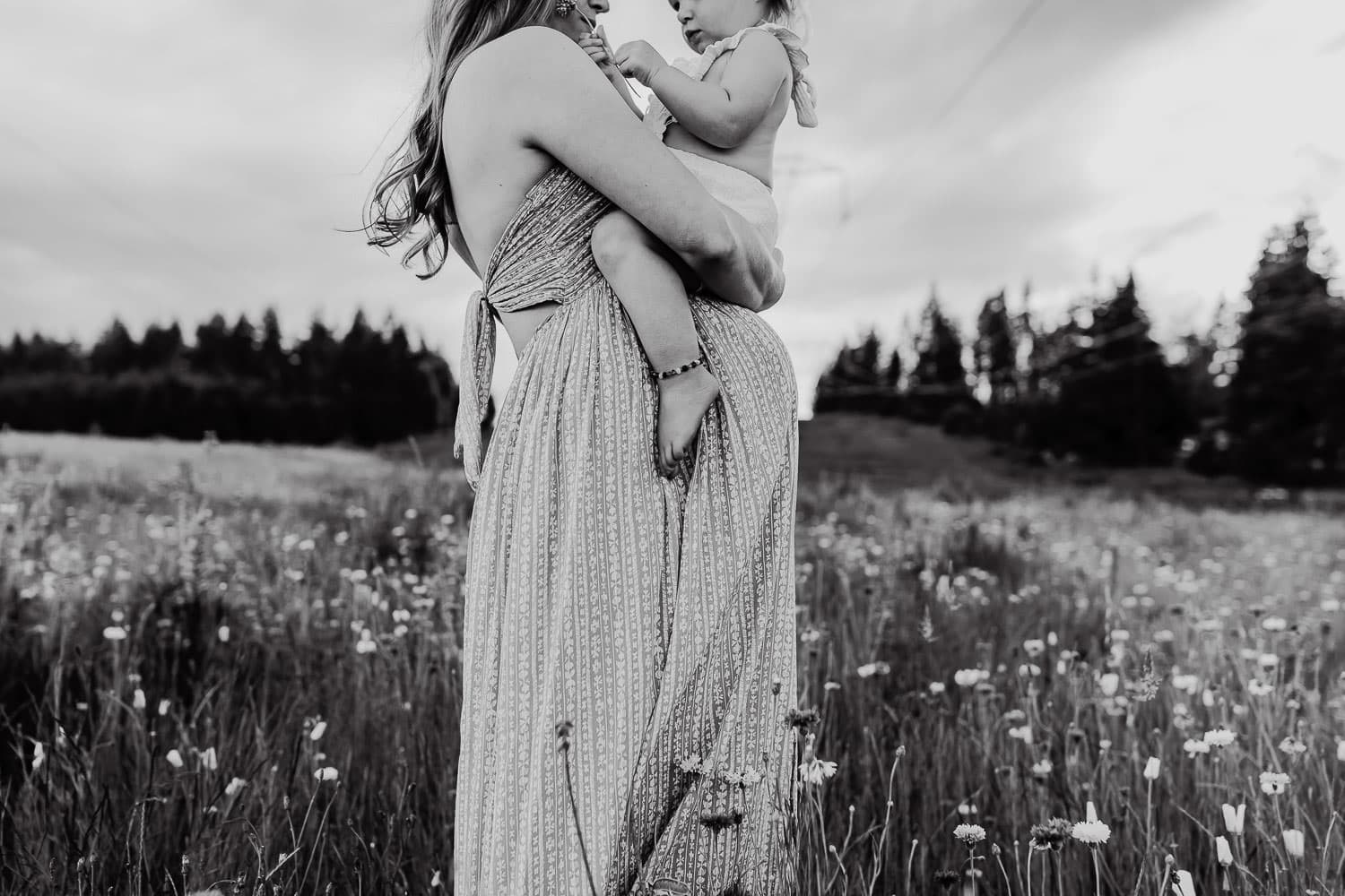 black and white image of pregnant mom holding her baby girl on her belly - maternity photographer in portland