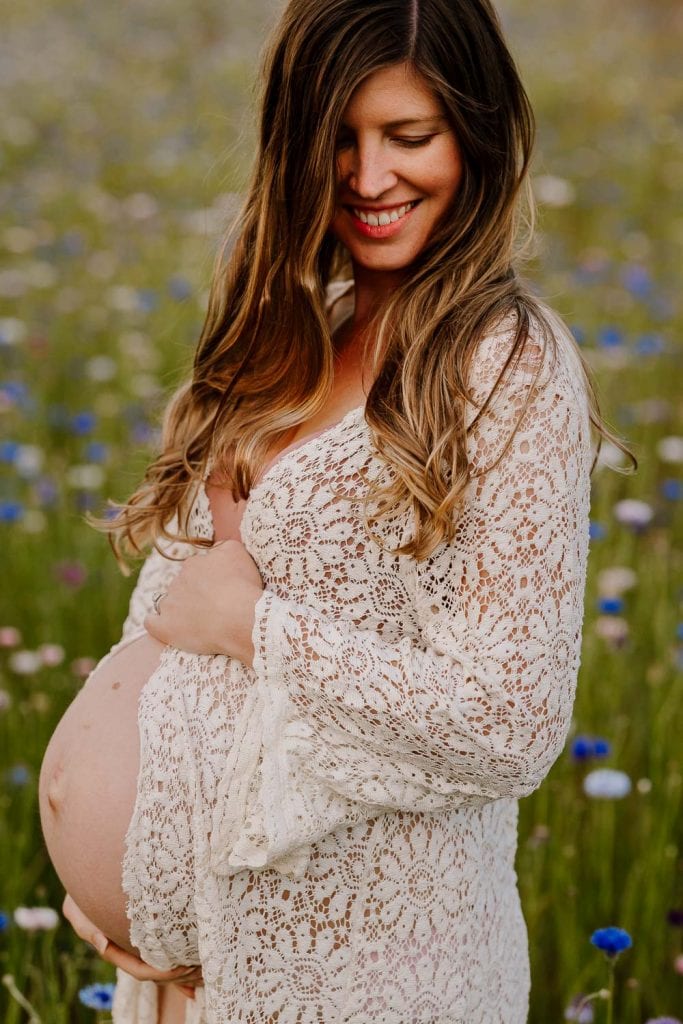 Beautiful pregnant mama to be wearing a lace duster in wildflowers