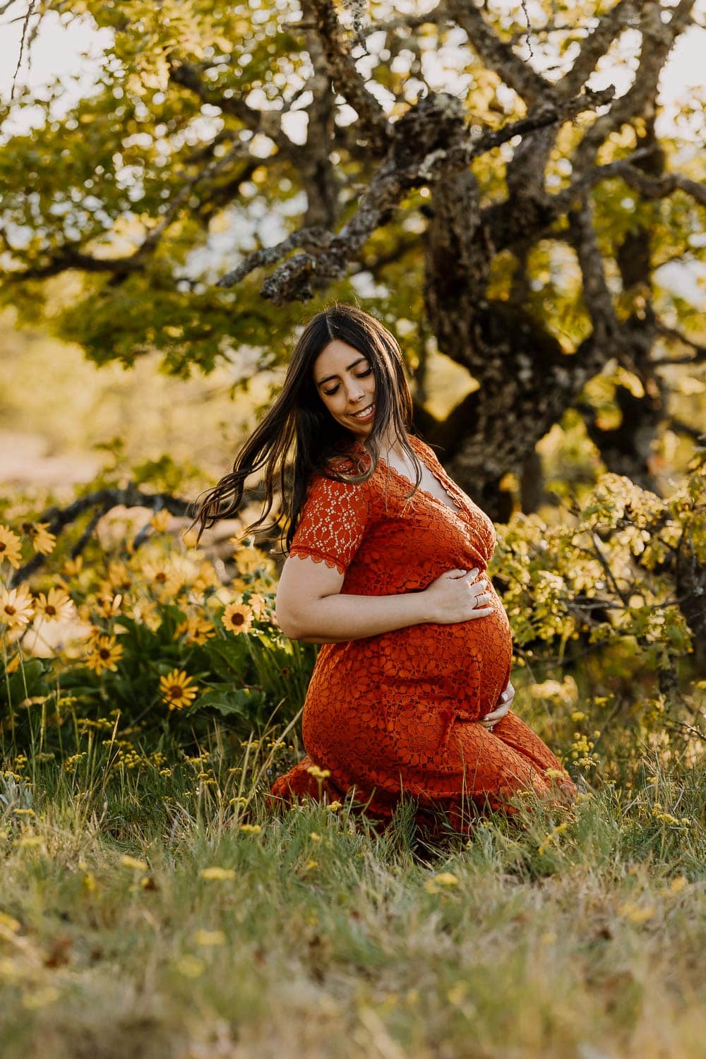 Maternity photo of mom on the ground with wildflowers surrounding her