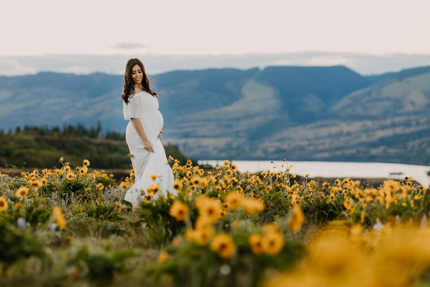 Wildflower photo of pregnant woman in white Baltic Born dress