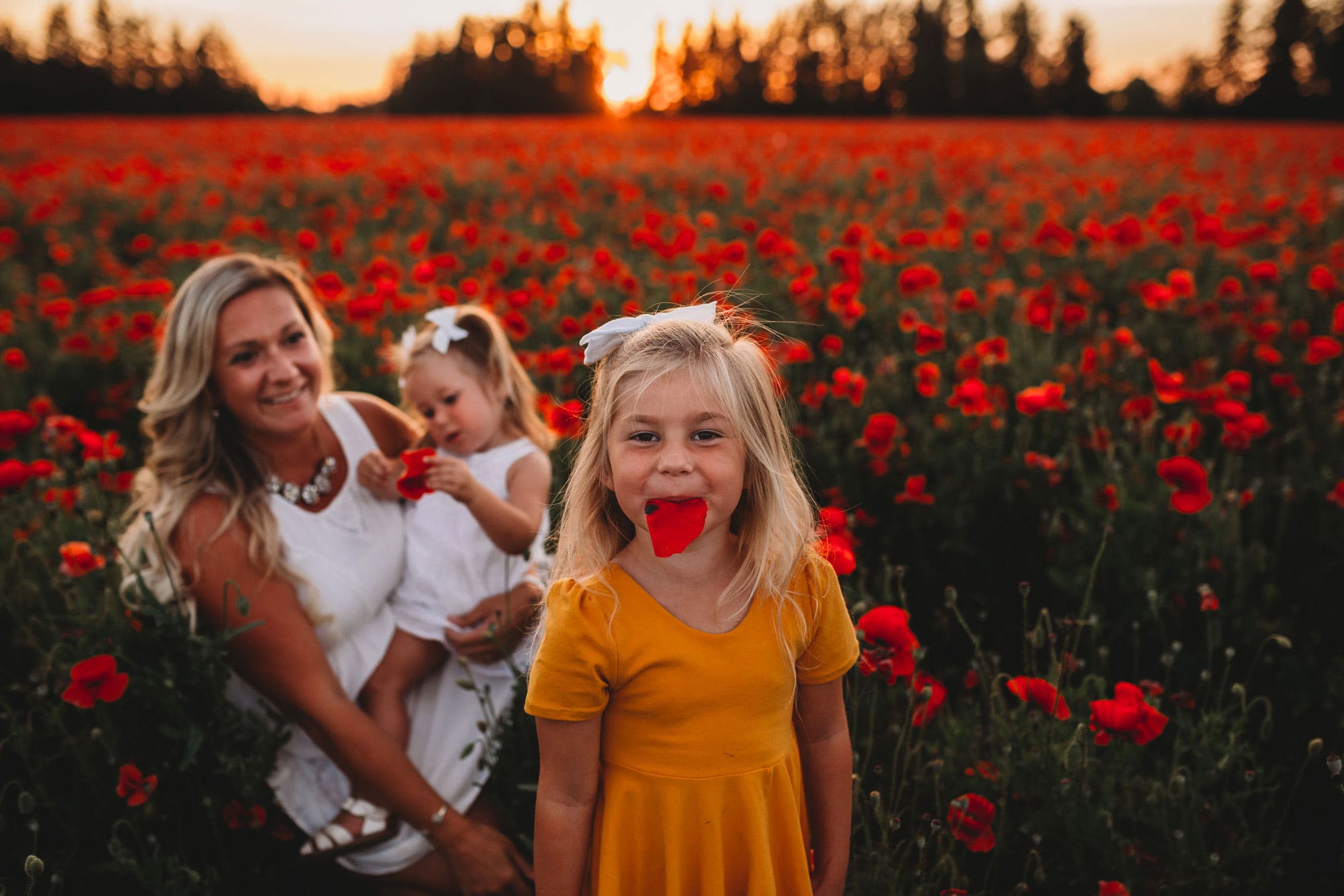 Little girl with poppy flower petal in mouth