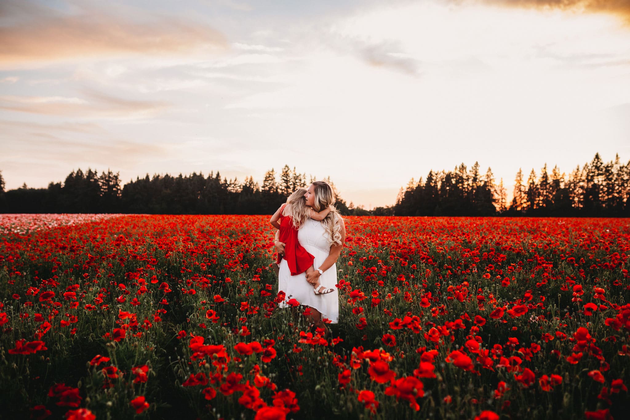Mom holding daughter in a poppy field in oregon