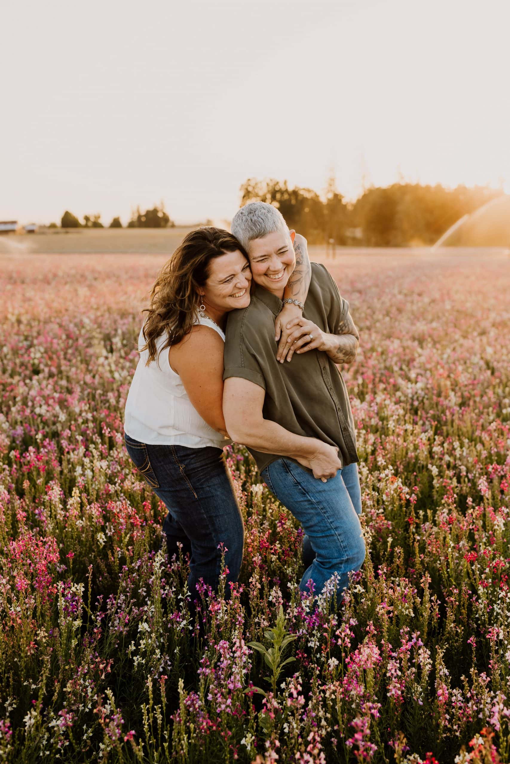 couple hugging and laughing in flower fields near portland oregon