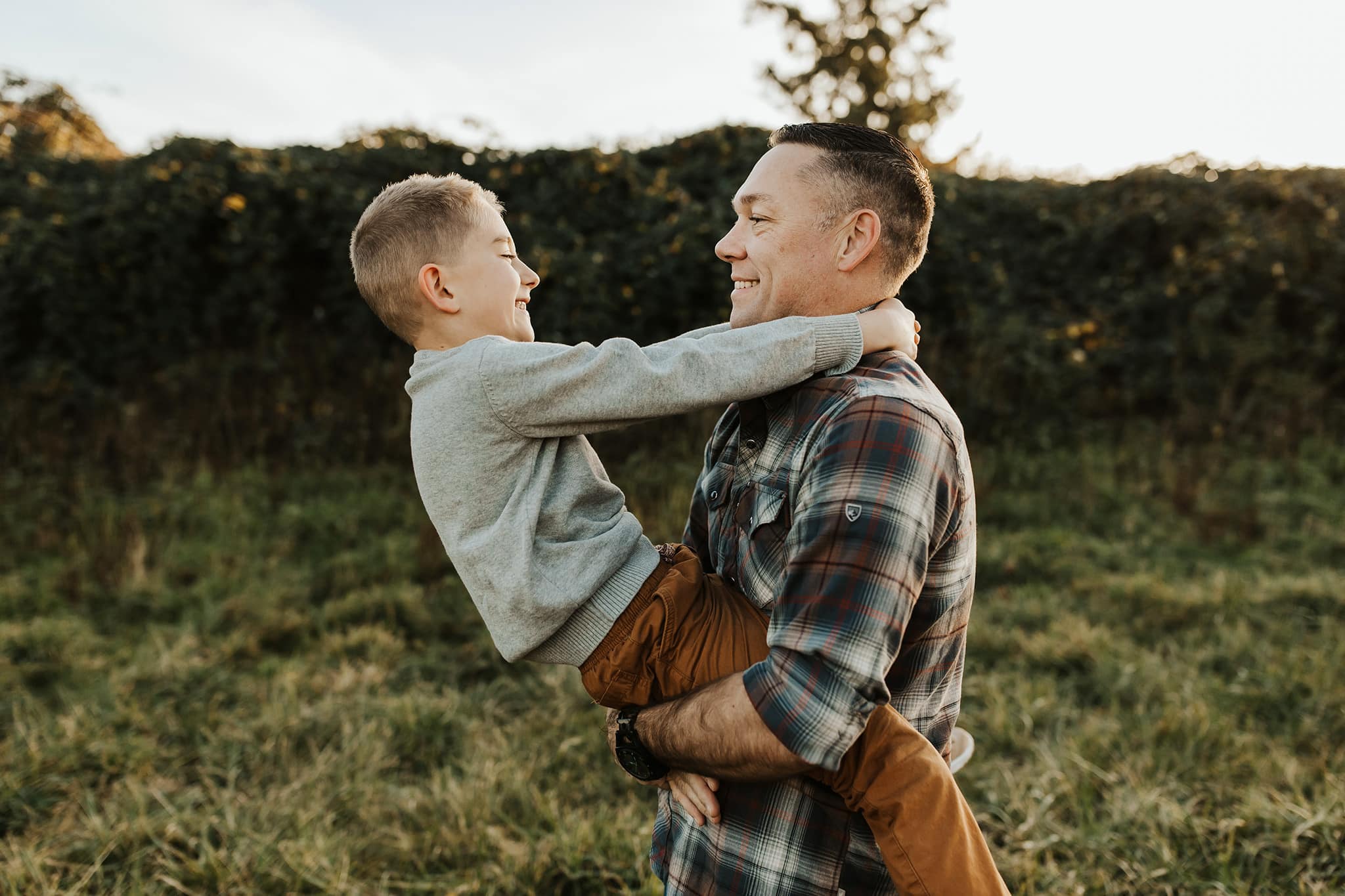 Dad holding son looking at each other - Portland candid family photographer
