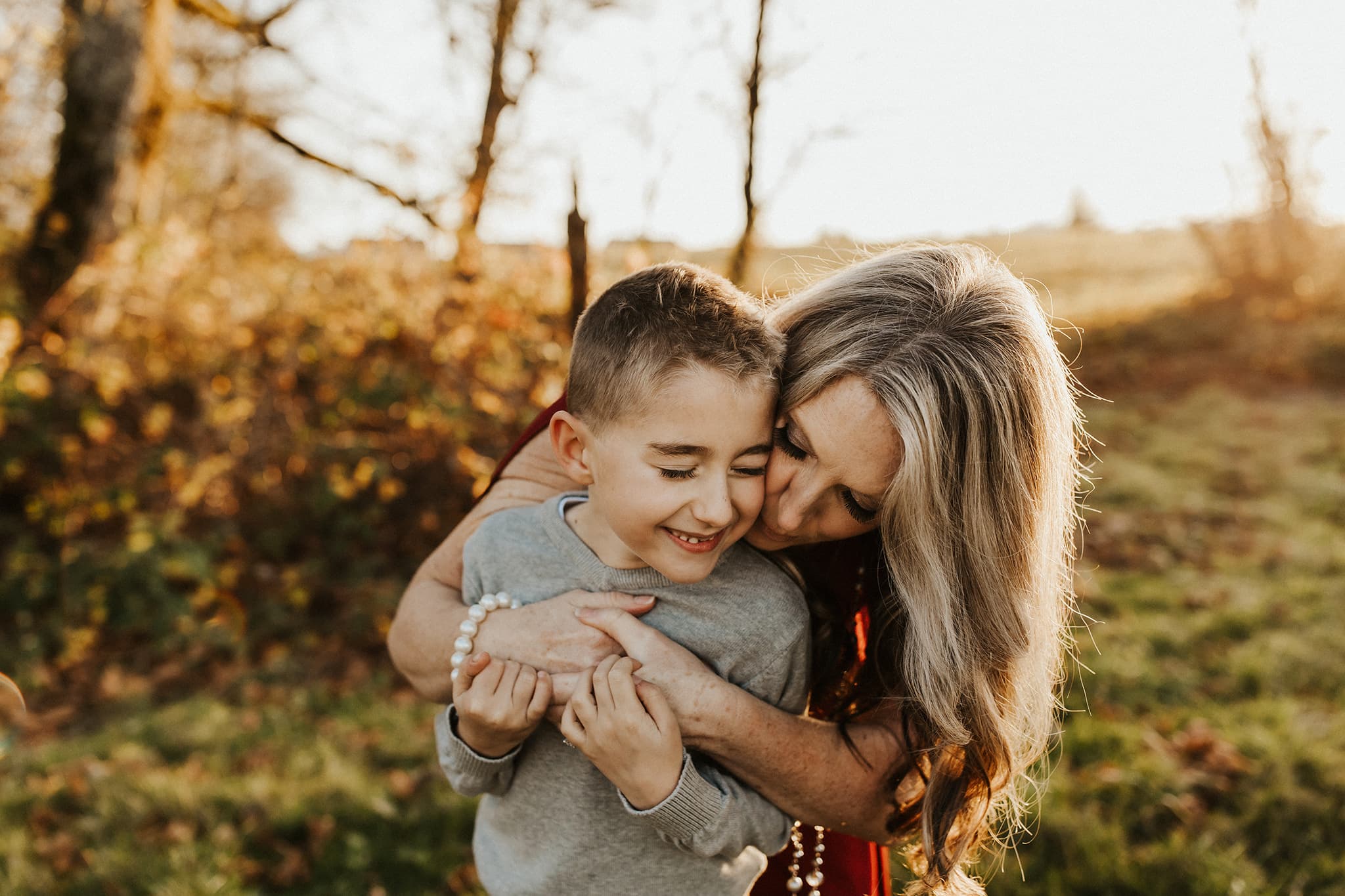 Mom leaning down and kissing sons cheek - Portland Candid Family Photographer
