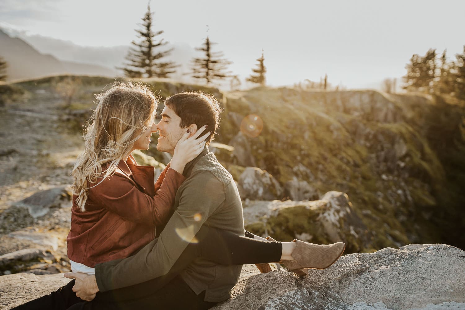 Woman sitting in husband's lap while almost kissing him - PDX Couples photography
