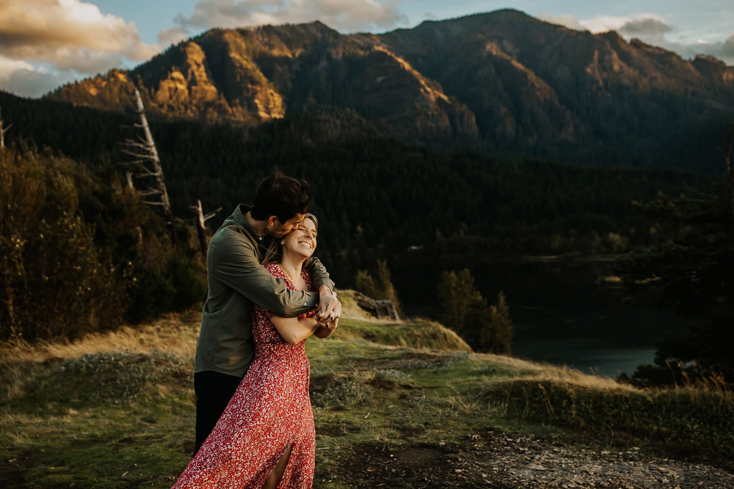 Engagement photographer near PDX - Couple hugging with mountains behind them
