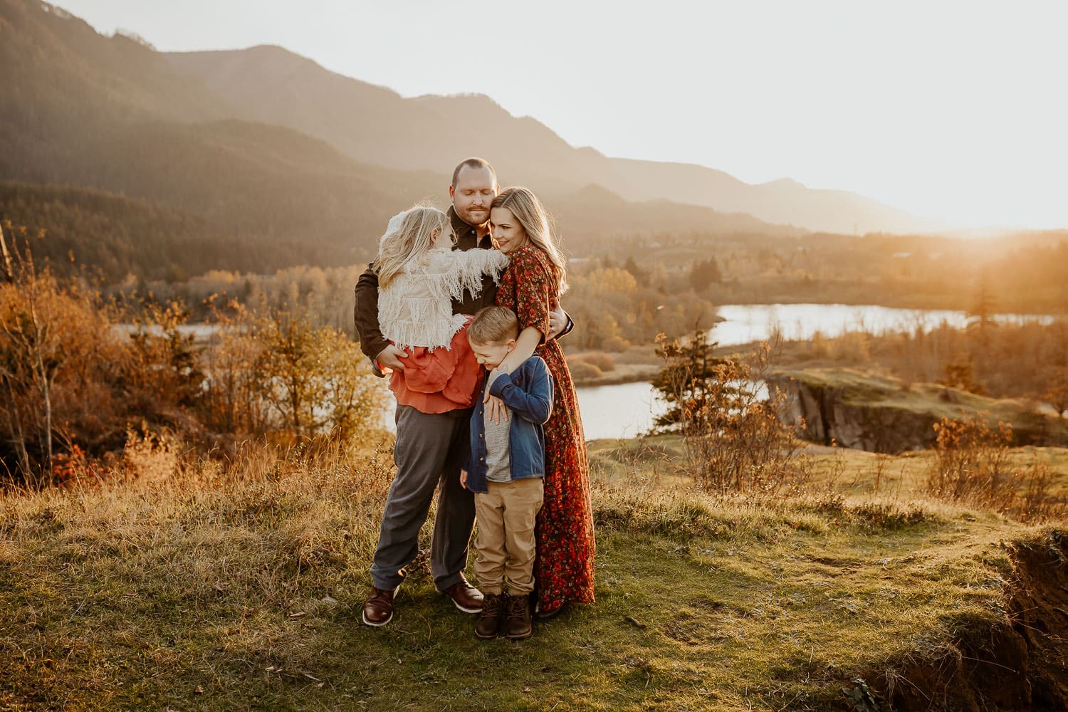 Family hugging and standing near a cliff with the columbia river behind them