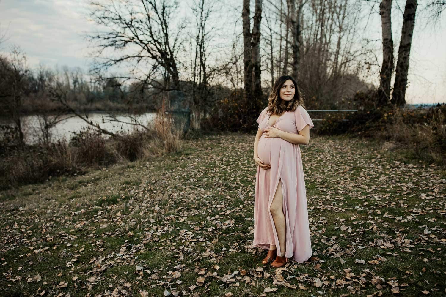 Pregnant woman in pink maxi dress in the winter