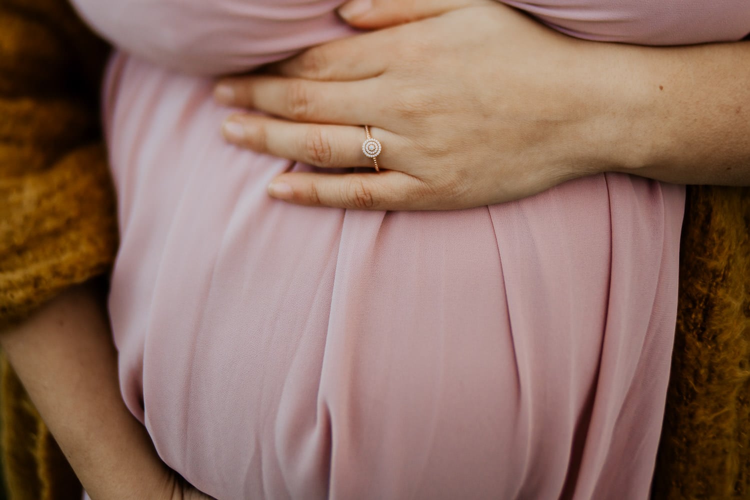 closeup of pregnant belly and wedding ring