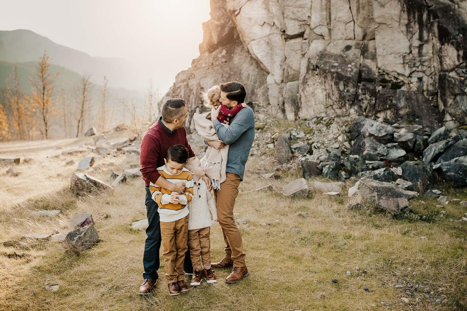 Family hugging each other with rocks behind them in Portland OR