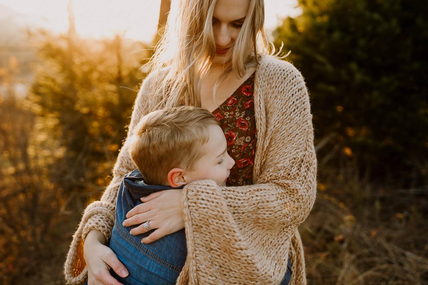 mom wearing a joyfolie floral dress hugging her 7-year-old son