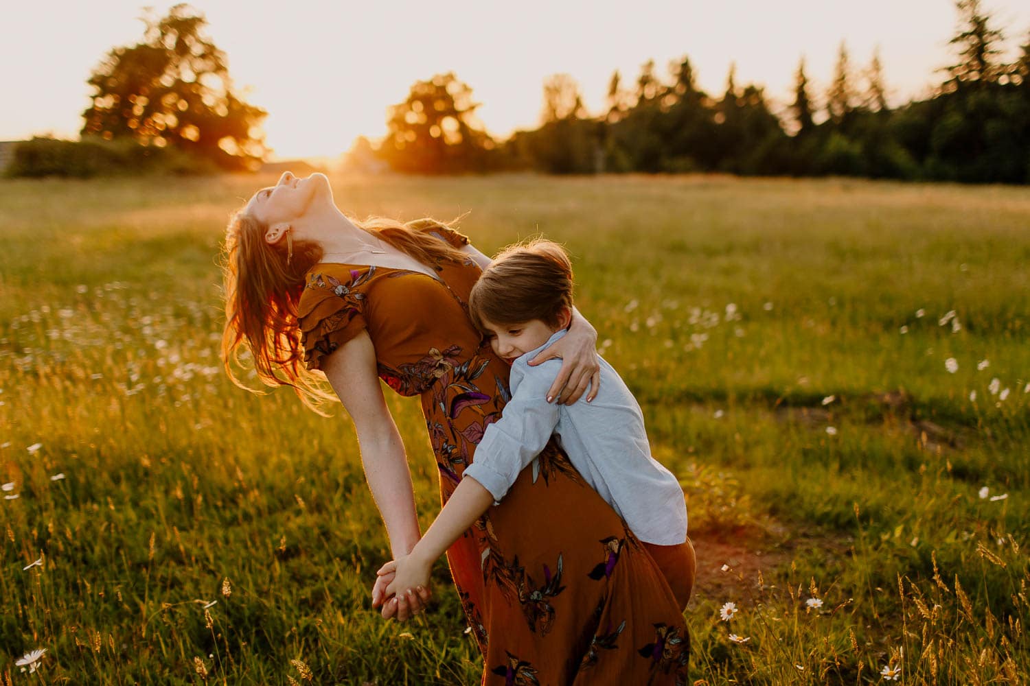 mom and son dancing in a field of daisies in portland oregon | how to start a photography business for beginners
