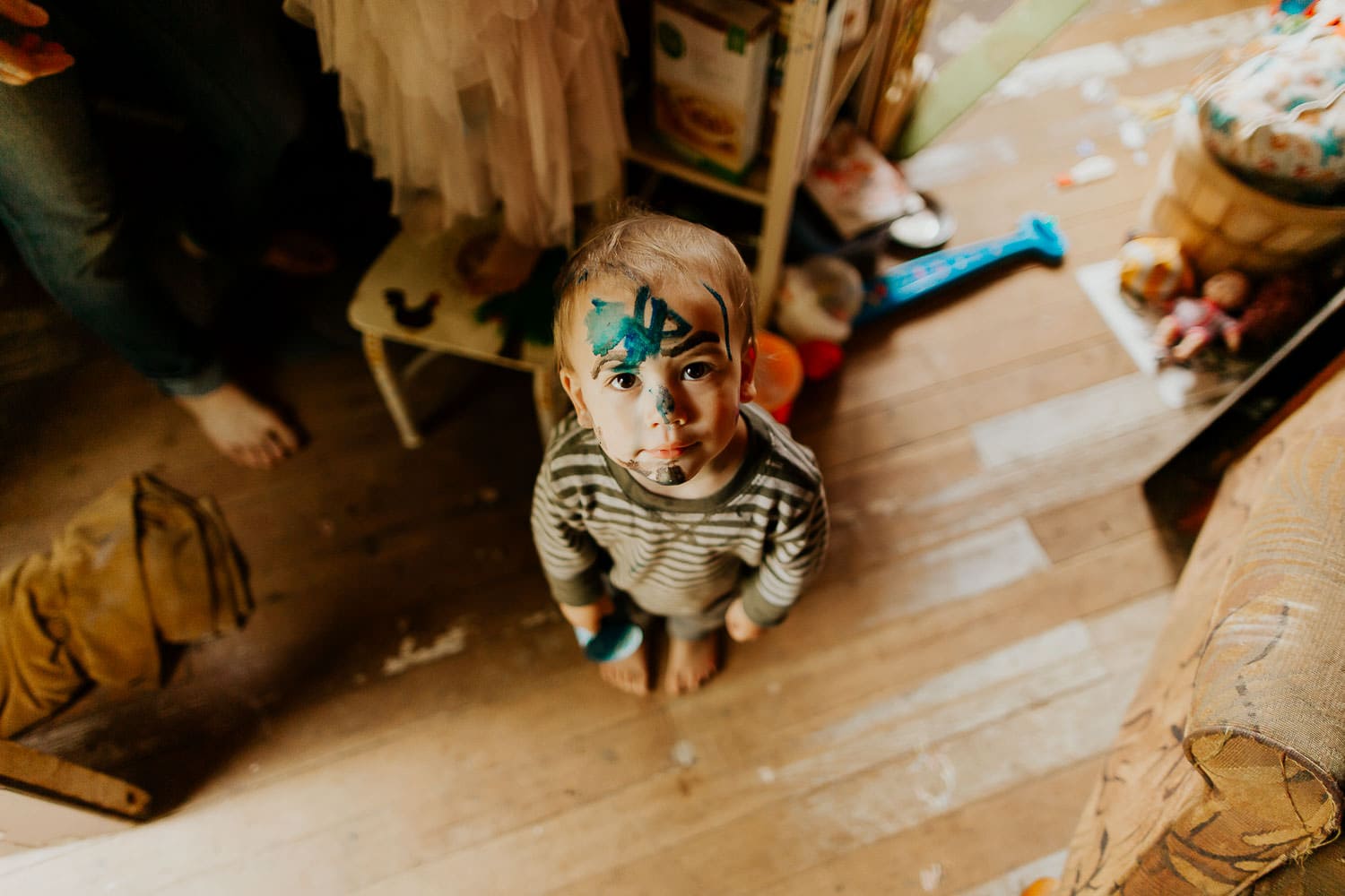 Little boy with face painted standing and looking up at camera - what to do at home with kids