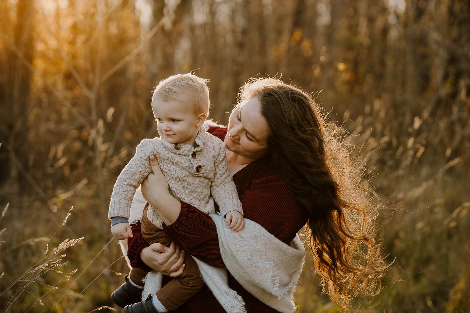Mom holding toddler son with the sun behind them - best tools for photographers