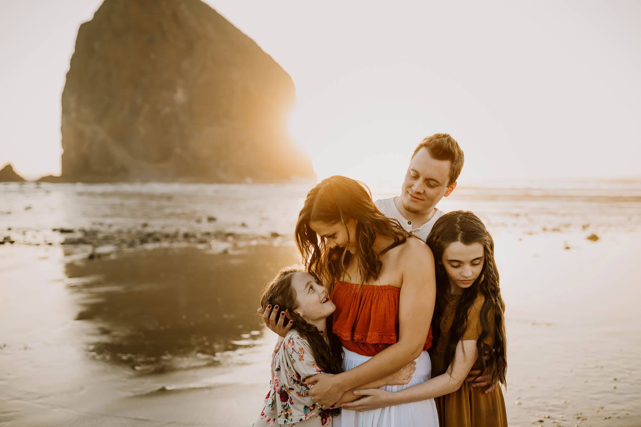 family hugging at sunset on the beach - oregon coast photographer