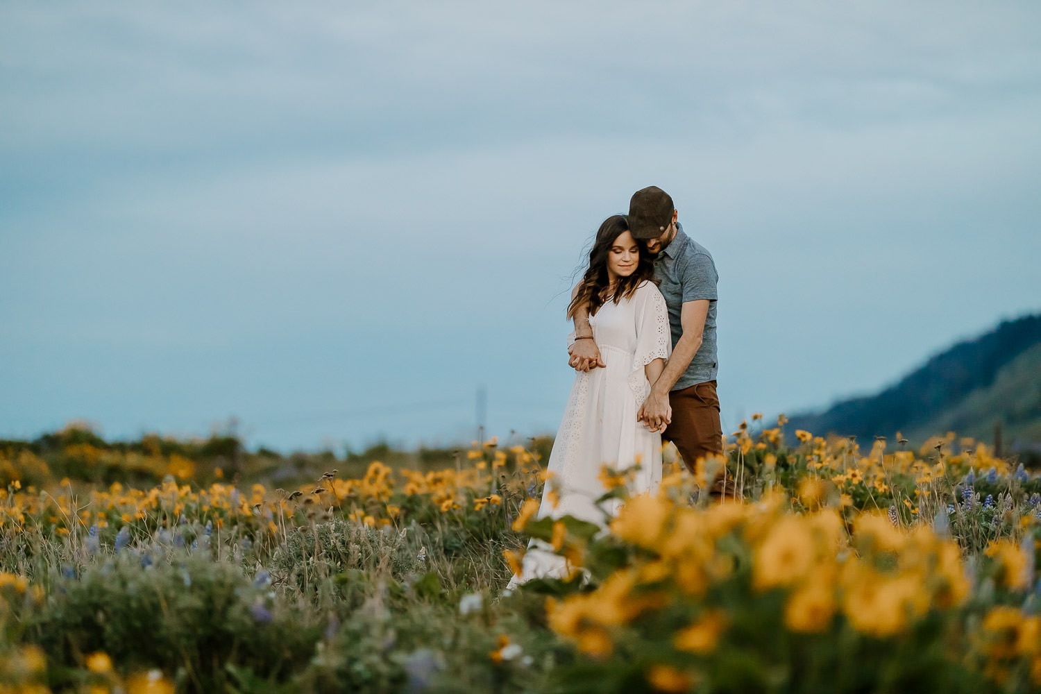 Couple holding hands and cuddling at the columbia river gorge wildflowers