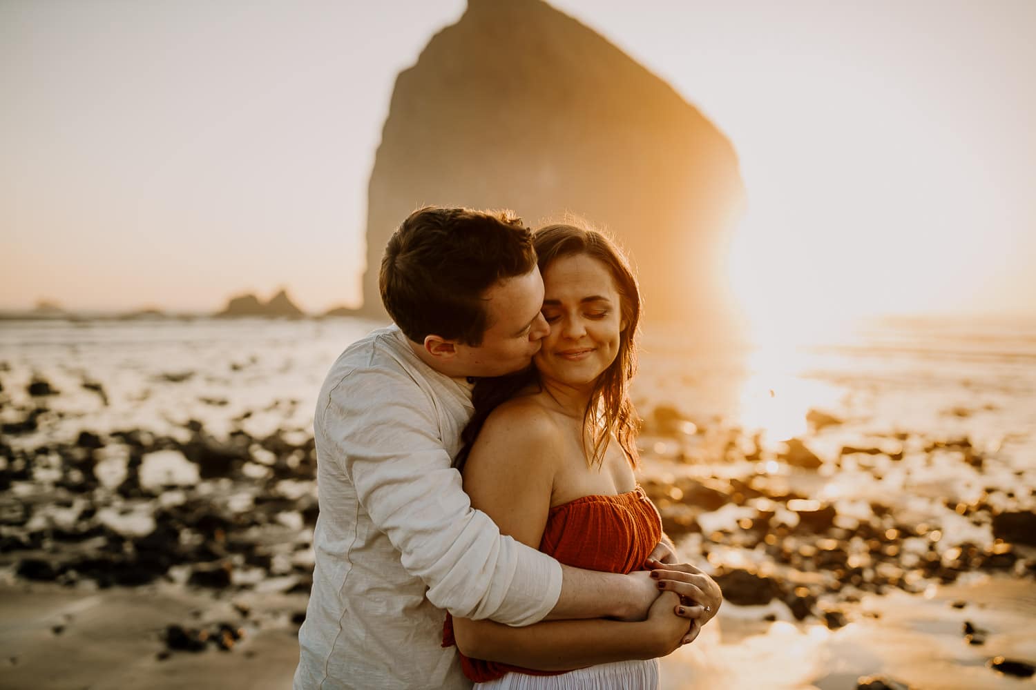 couple cuddling in the sunset at the oregon coast - couples photographer