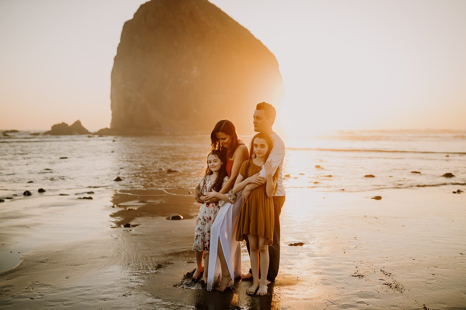 Oregon coast family photographer image of family cuddling in the golden light