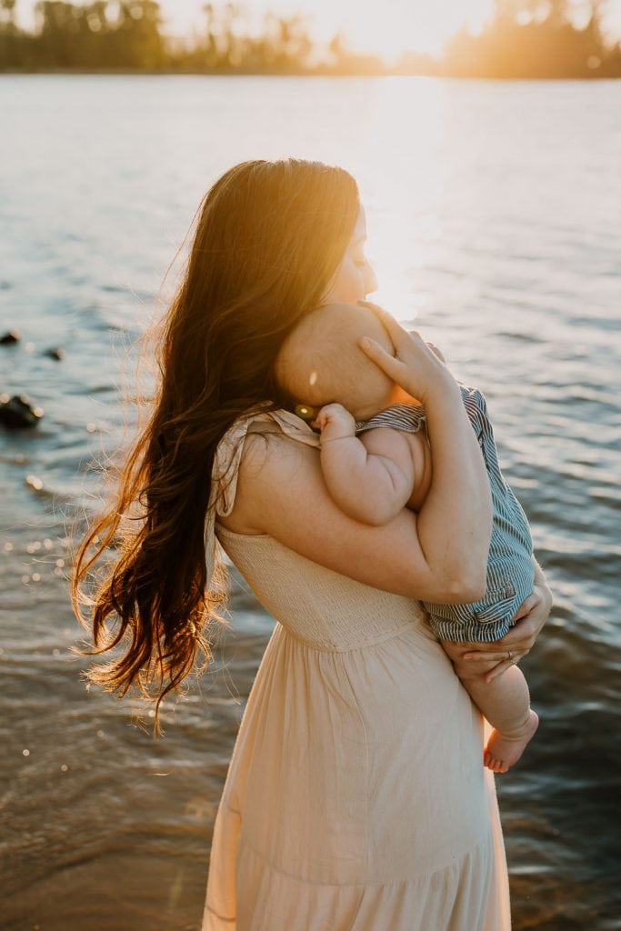 Mom with long wavy hair holding her son tightly