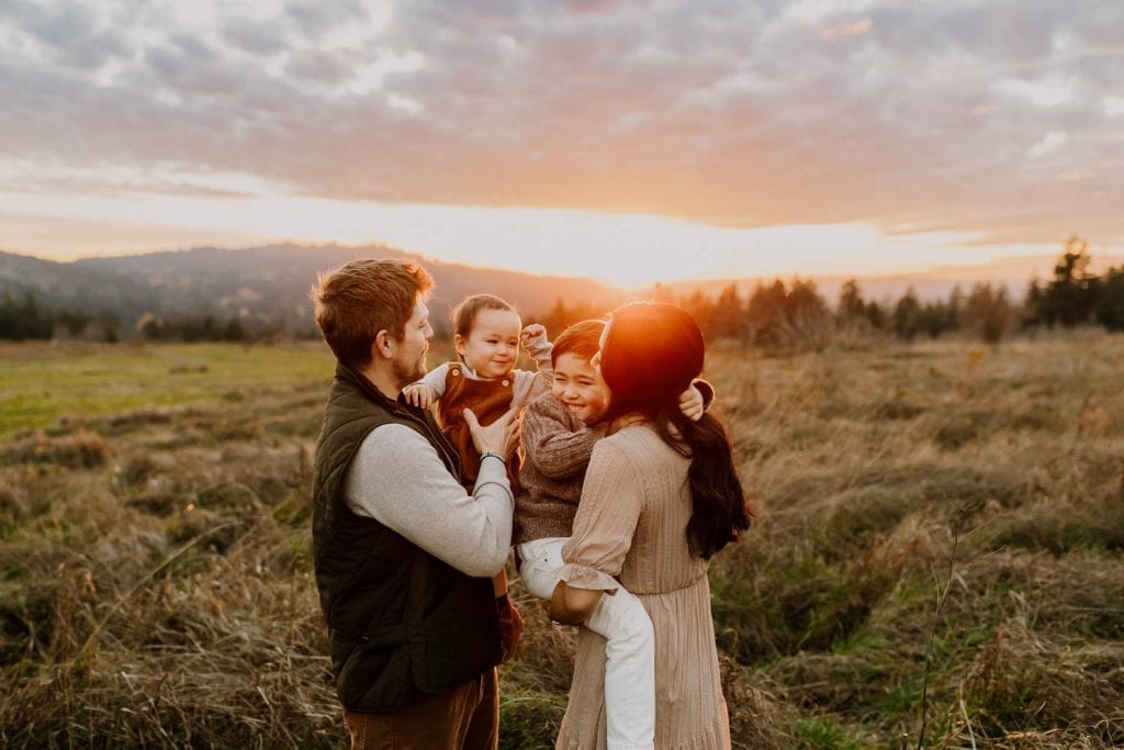family laughing and cuddling together during family photos in Portland