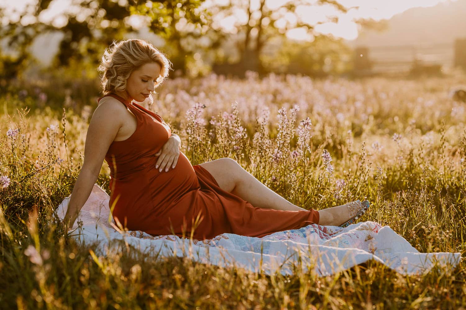 Beautiful mom sitting in a field of camas lilies during maternity photos - portland oregon photo location