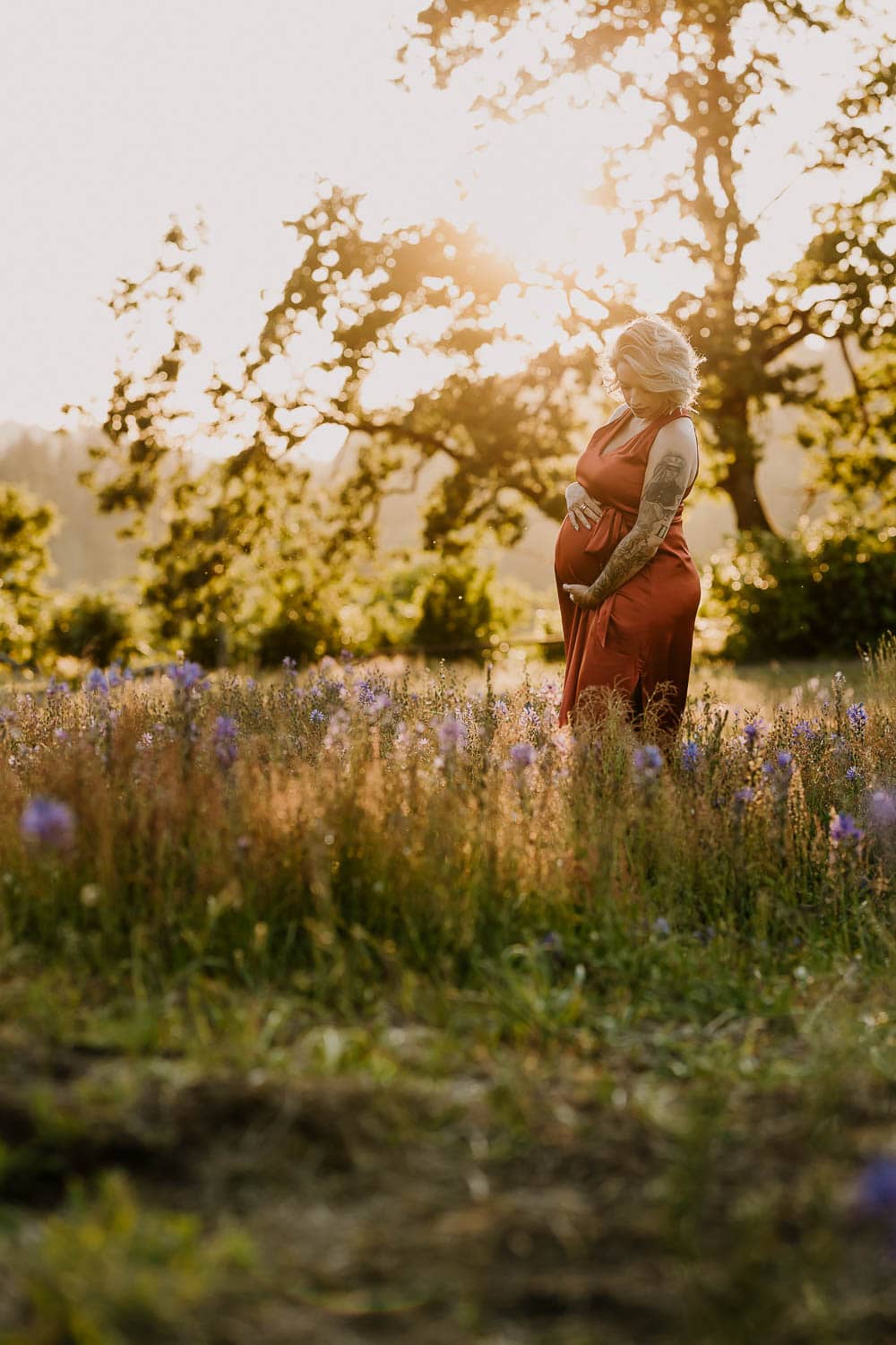 Pregnant mom at sunset during maternity photos in a spring lily field location in portland