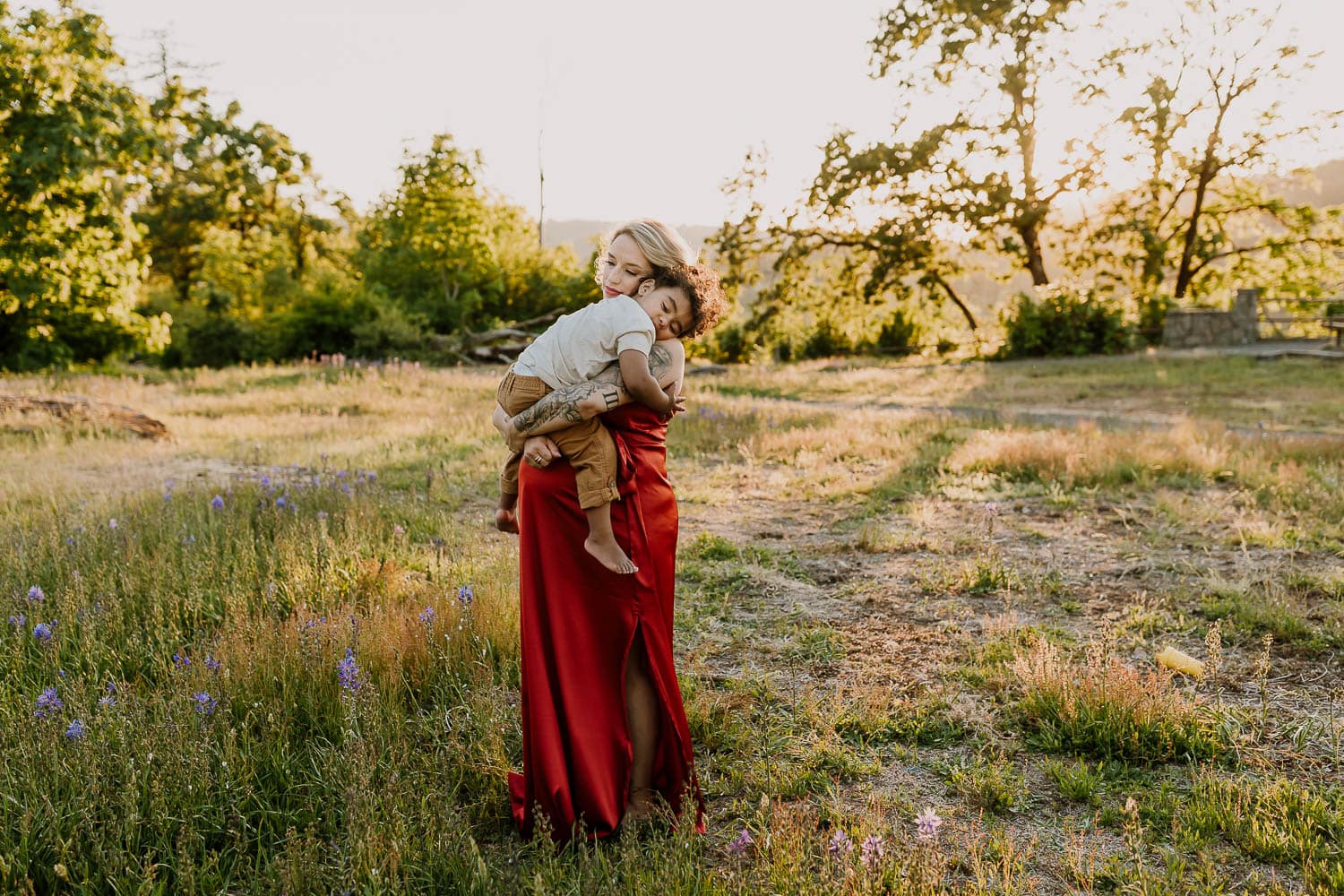 Pregnant Mom cuddling baby boy in a field of flowers near portland oregon