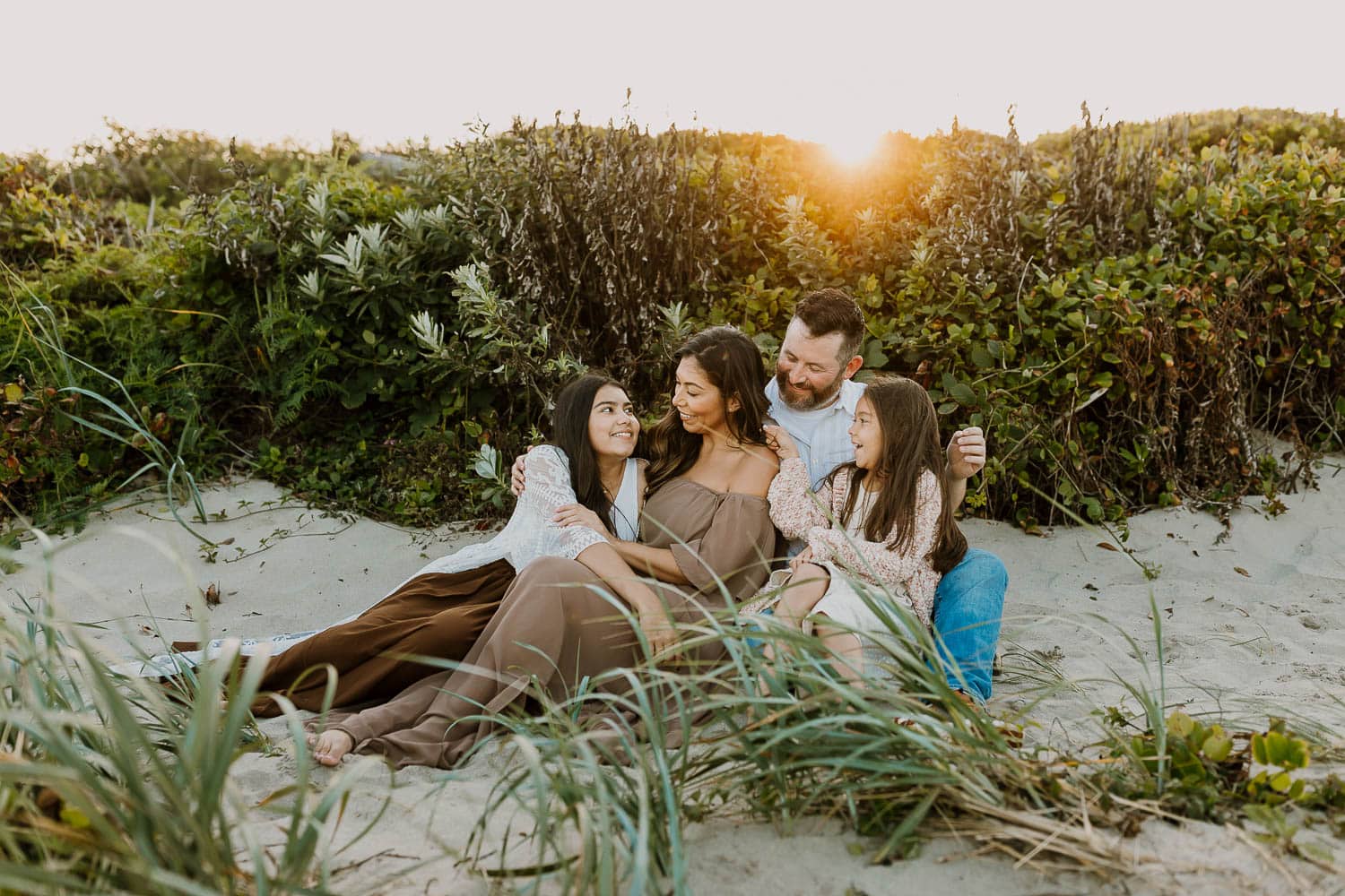 Family of four sitting on the sand near rockaway beach oregon