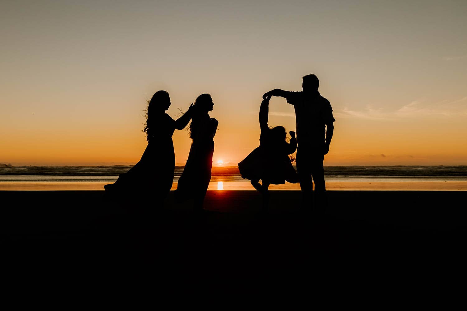 silhouette of a family on the beach in rockaway oregon