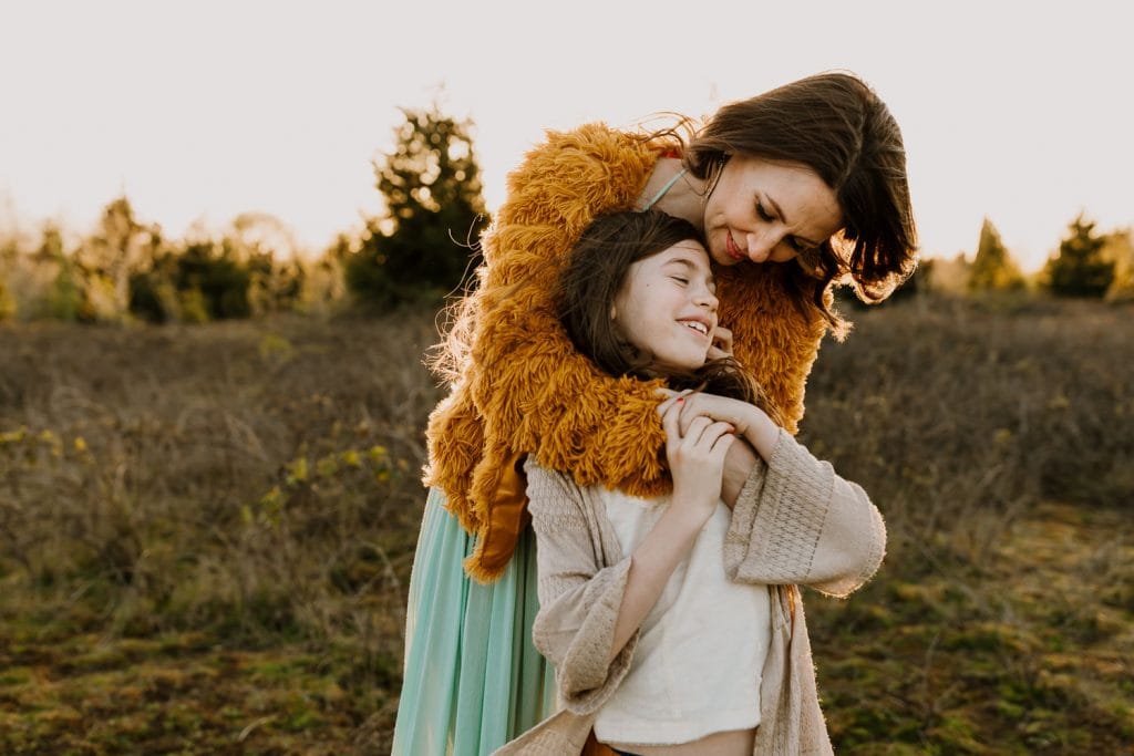 Mom hugging onto her daughter n the sunset during family photos in Portland
