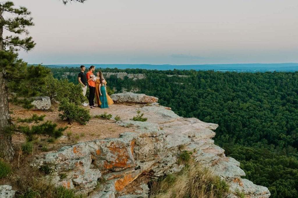 Arkansas family playing near a rock cliff during destination family photos and video session