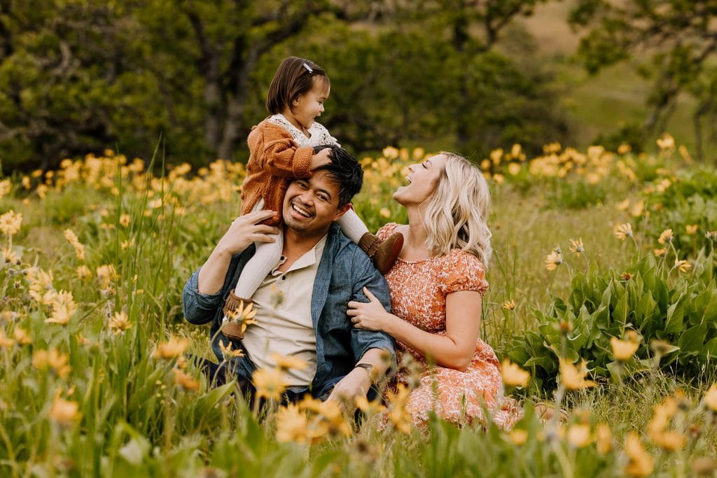 Family sitting in a field of wildflowers in the columbia river gorge