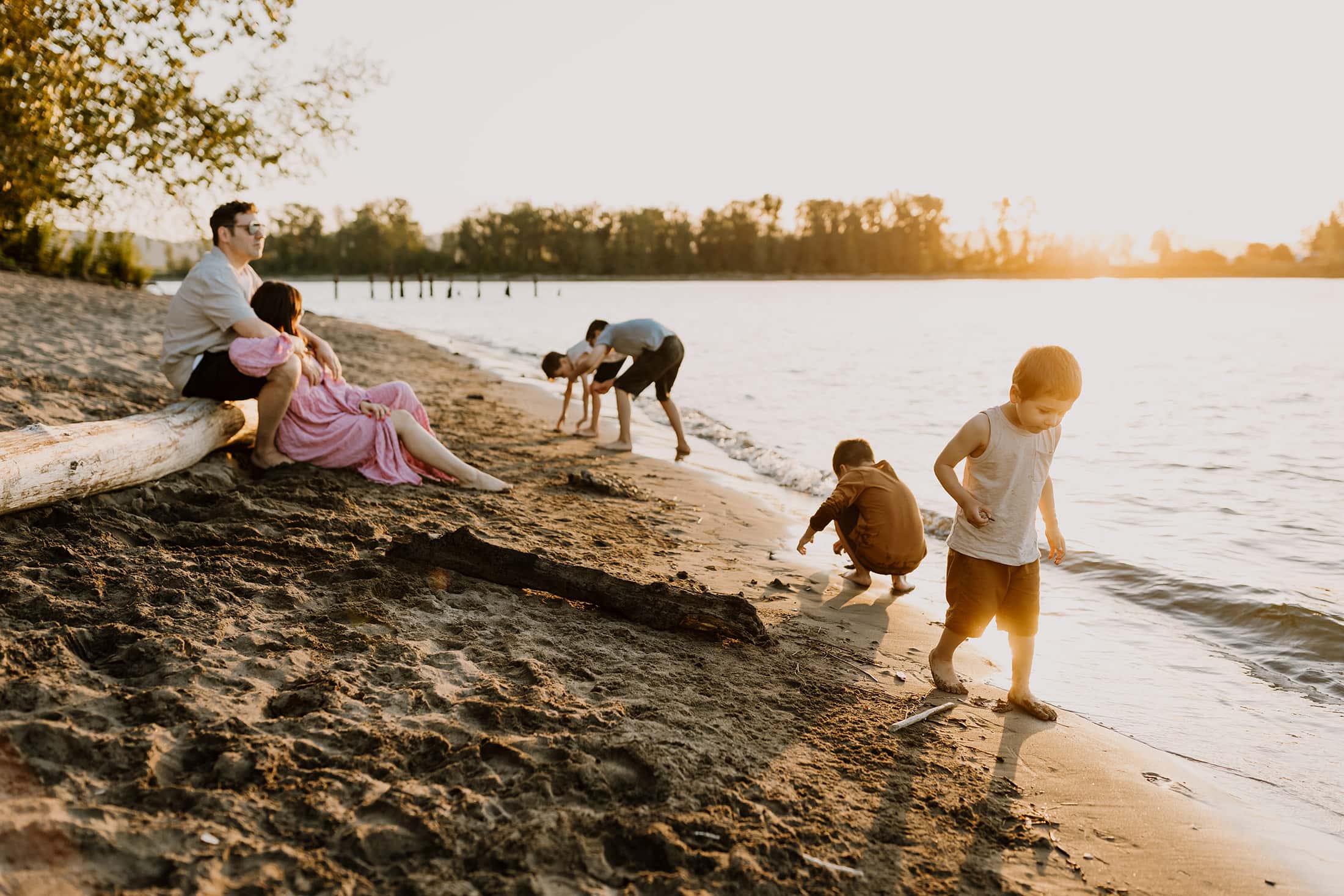 large family playing in the sand along a river in Portland Oregon