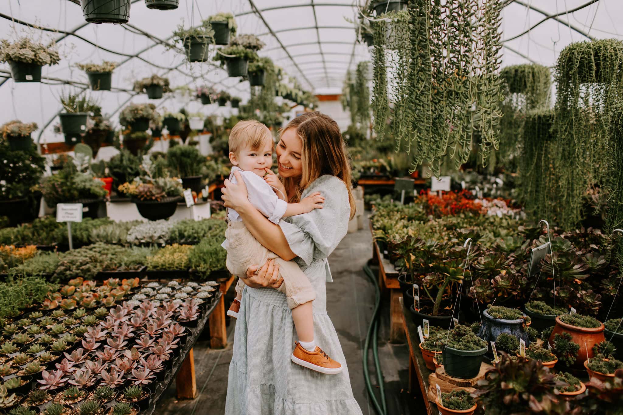 Mom and son dancing together in a greenhouse near vancouver washington during family photos