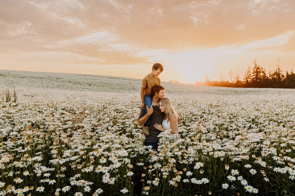 Mom, dad, and son in a huge field of flowers