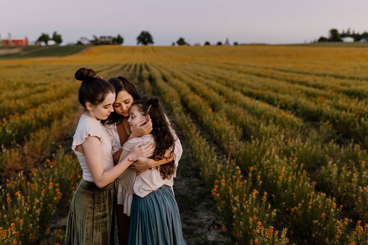 Mom embracing her two girls while standing in a Silverton, Oregon wildflower field