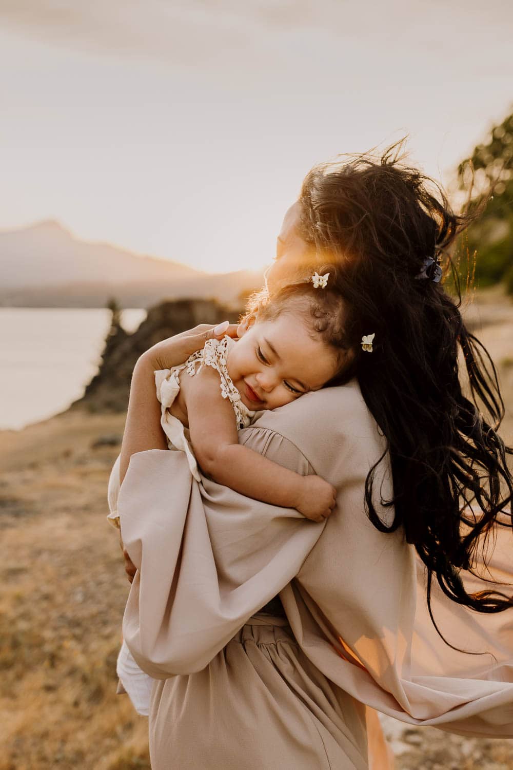 Mother embracing baby girl in the sunset light