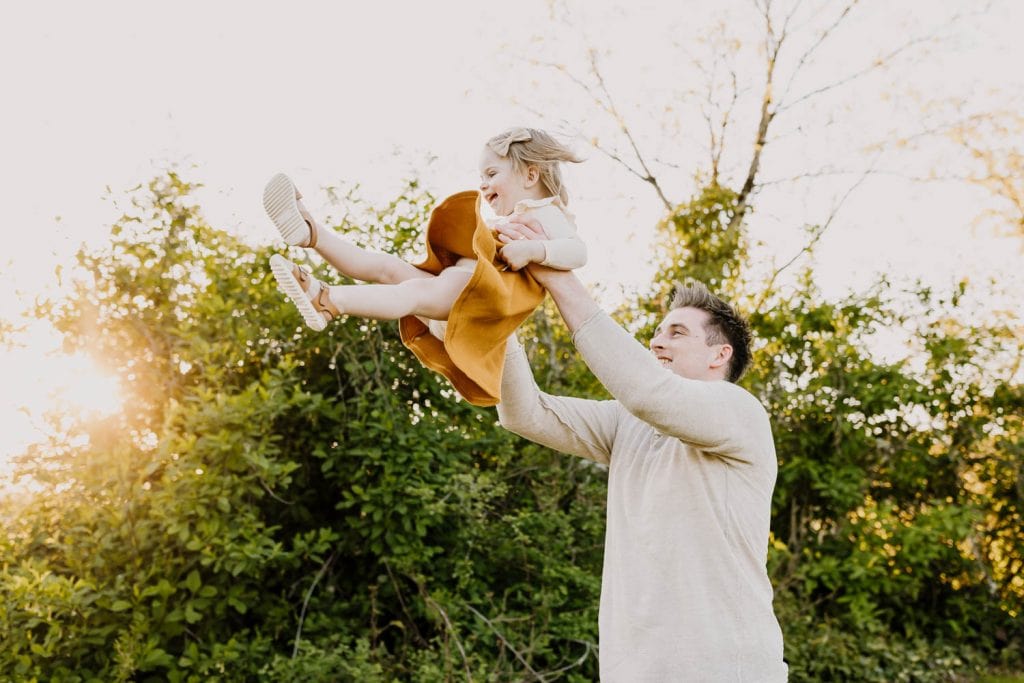 Dad throwing toddler in the air