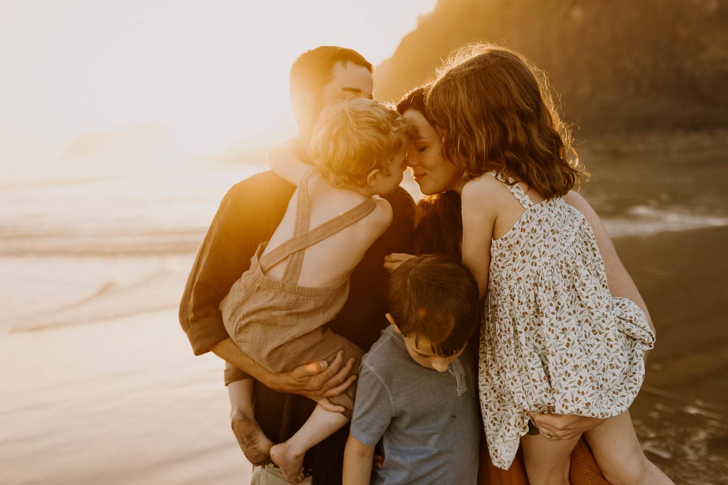 Family of five embracing at sunset