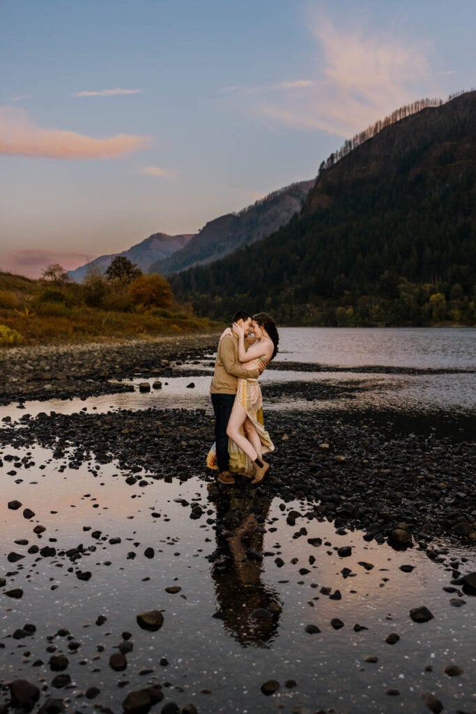 couple embracing in the mountains with reflection in water